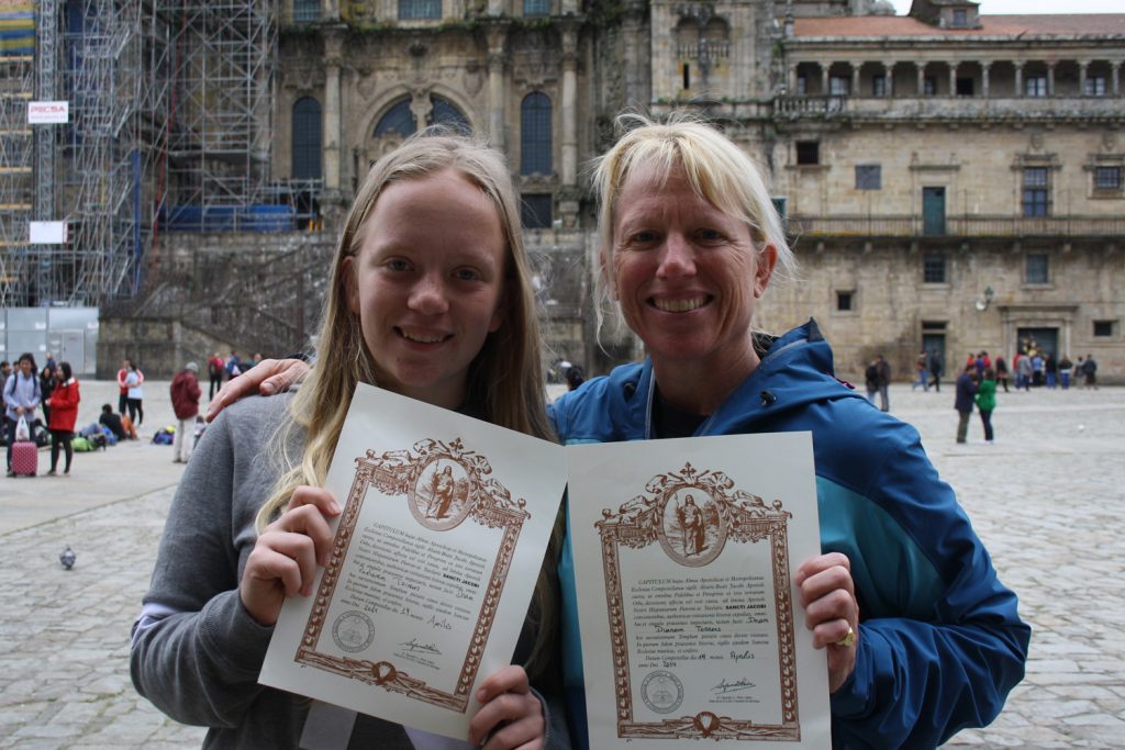 Happy pilgrims with their Camino certificates along the Camino de Santiago.