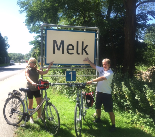 Two cyclists pose beside the sign for Melk on the Danube river path cycling trip