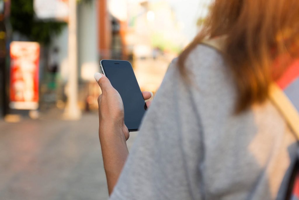 girl looks at phone on asian street