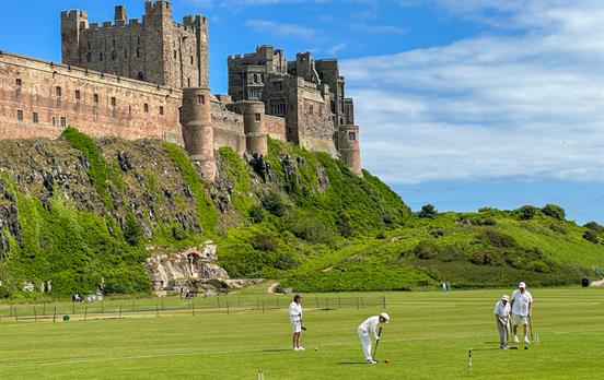 Croquet club playing below Bamburgh Castle