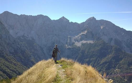 Walking in the Julian Alps beneath clear blue skie