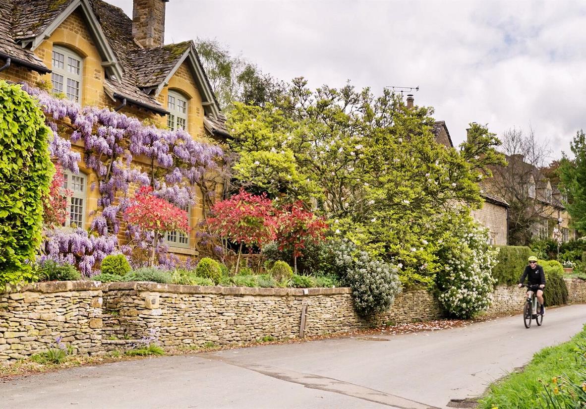 Wheeling past classic Cotswolds cottages.