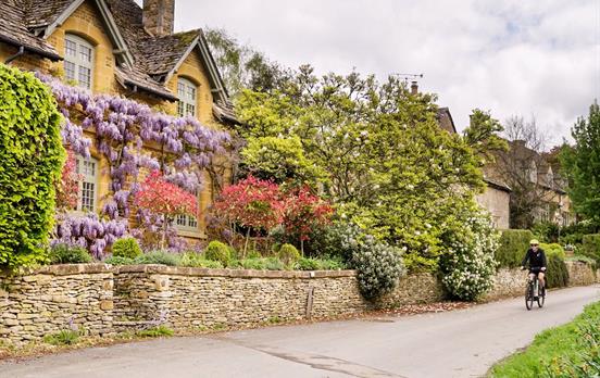 Cycling past classic Cotswolds cottages.