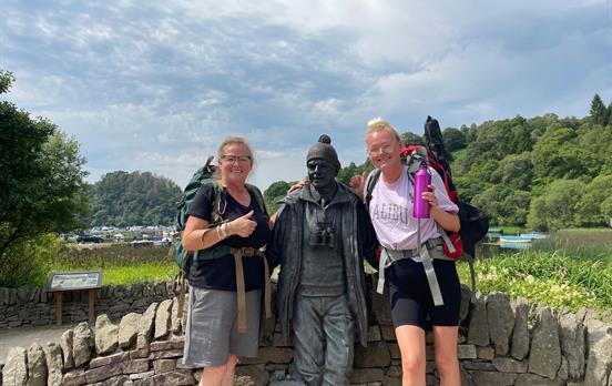 Walkers with Tom Weir statue in Balmaha