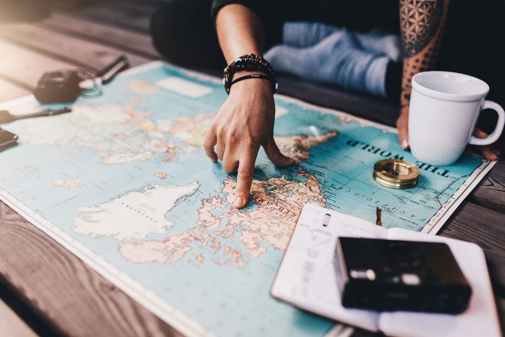 Traveller plans their adventure in front of a world map