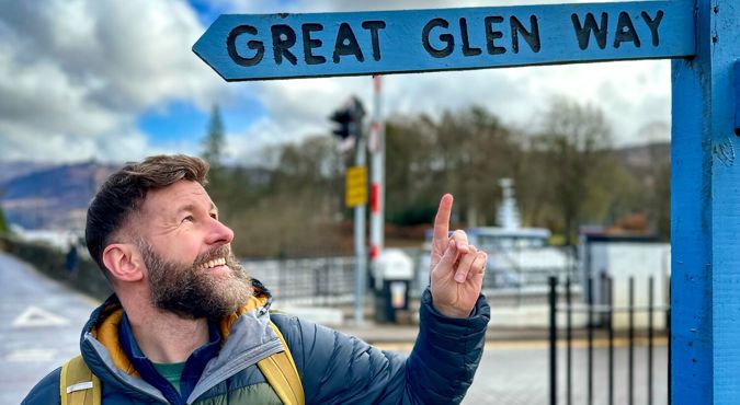 Man pointing to sign saying Great Glen Way