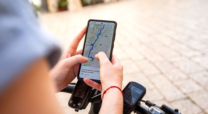 person holding mobile phone looking at a GPS map