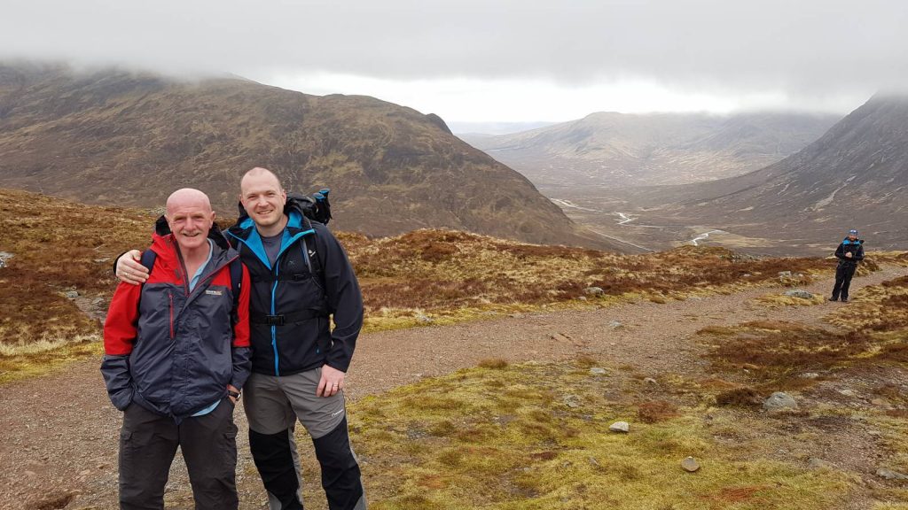 two hikers celebrate at the top of the devils staircase on the west highland way